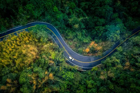 Aerial shot of car on windy road.