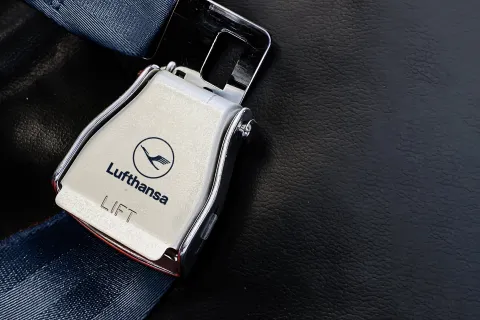 airplane passenger seat safety belt with the Lufthansa logo printed on the metal