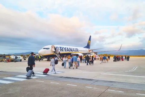 Travelers Boarding Ryanair Plane at Airport Runway during Sunset
