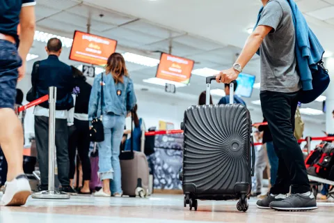 people waiting for check in at airport. A man and luggage at the airport terminal.