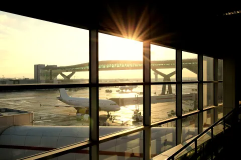 Airport departure lounge with passenger plane being loaded.