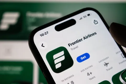 Closeup of a smartphone screen displaying the frontier airlines mobile application page on the apple app store
