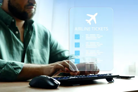 Travel booking for airline tickets using a computer at a desk during the day