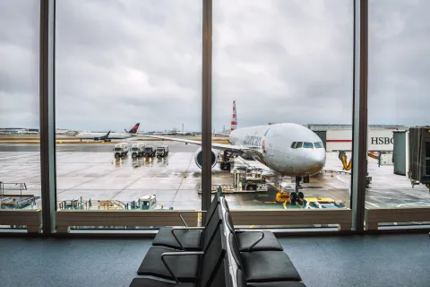 Airplane of American Airlines being serviced at the London Heathrow airport, as seen from the waiting hall.