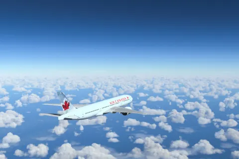 Commercial Boeing 777-200 Air Canada flying over the blue sky