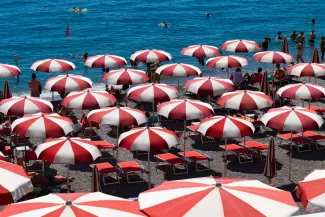 Amalfi beach on famous Amalfi Coast Italy. Rows of red and white parasols or beach umbrellas.