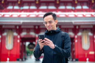 Tourist using cell phone in Asakusa Tokyo, Japan 