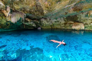 woman floating in cenote 