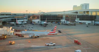American airlines plane parking during sunset in a busy DFW International airport