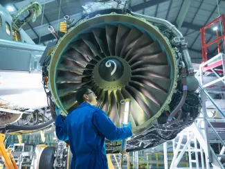 Engineer inspecting jet engine in aircraft maintenance factory