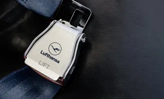 airplane passenger seat safety belt with the Lufthansa logo printed on the metal