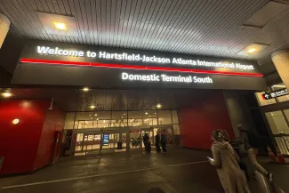 Travelers walk towards an entrance to Hartsfield-Jackson Atlanta International Airport Domestic Terminal in Atlanta, Georgia