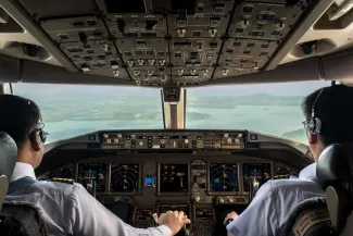 Inside cockpit of commercial airplane while fly approaching the runway. 