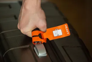 Closeup of a big suitcase tagged as Heavy