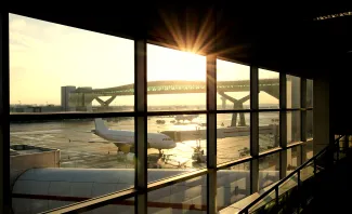 Airport departure lounge with passenger plane being loaded.