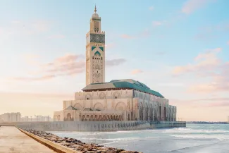 Hassan II Mosque overlooking the Atlantic Ocean in Casablanca, Morocco, with beautiful sunset colors illuminating