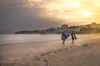 Sydney, NSW/Australia: Surfers leaving Bondi beach in the evening
