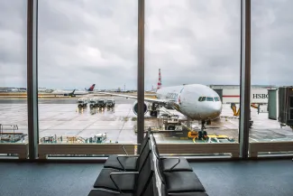 Airplane of American Airlines being serviced at the London Heathrow airport, as seen from the waiting hall.