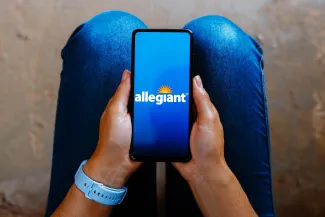 Allegiant Air logo is displayed on a smartphone screen.