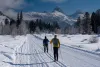 Two men classic Nordic skiing in Teton Canyon near Driggs Idaho and Alta, Wyoming, Grand Teton in distance