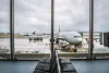 Airplane of American Airlines being serviced at the London Heathrow airport, as seen from the waiting hall.