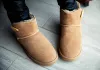 Girl in brown ugg boots in leather pants. Fashion, style, modern. Grey wood floor